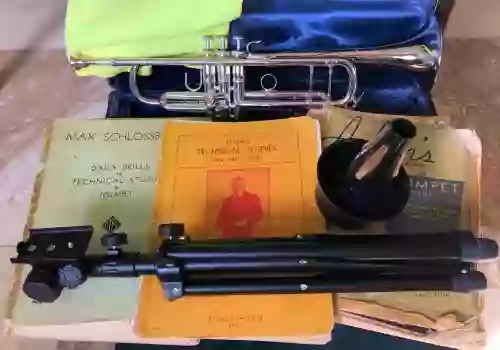 My trumpet Accessories. Vincent Bach trumpet, method books, mute, and stand in front of my 1970's Bach Stradivarius trumpet in it's case.