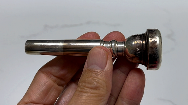 A very dirty and tarnished Yamaha Bobby Shew Jazz Trumpet mouthpiece in my left hand